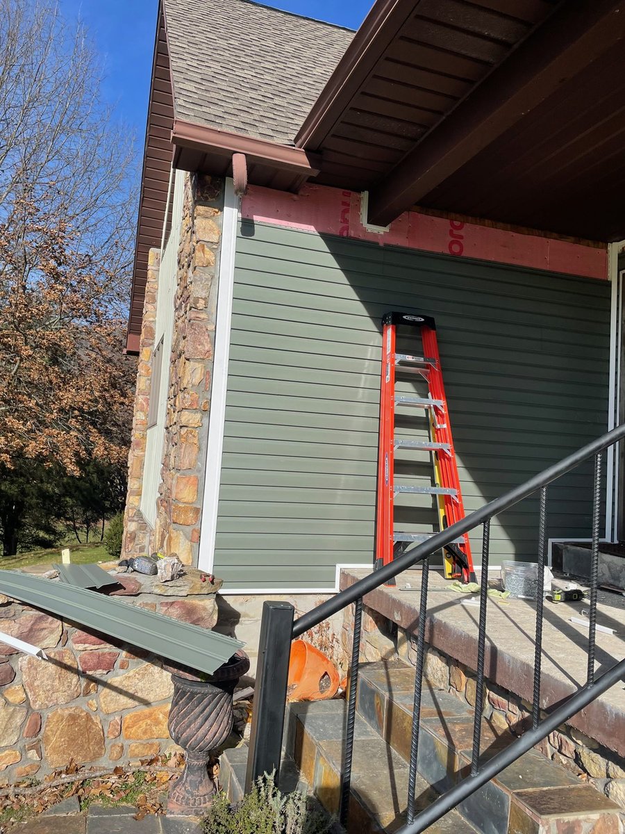 Siding after replacement — new siding cut in around the stone